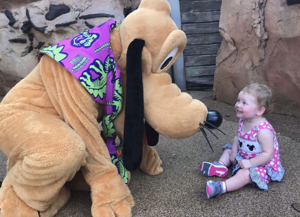 Pluto stoops down to the level of a child and brings her delight and joy.