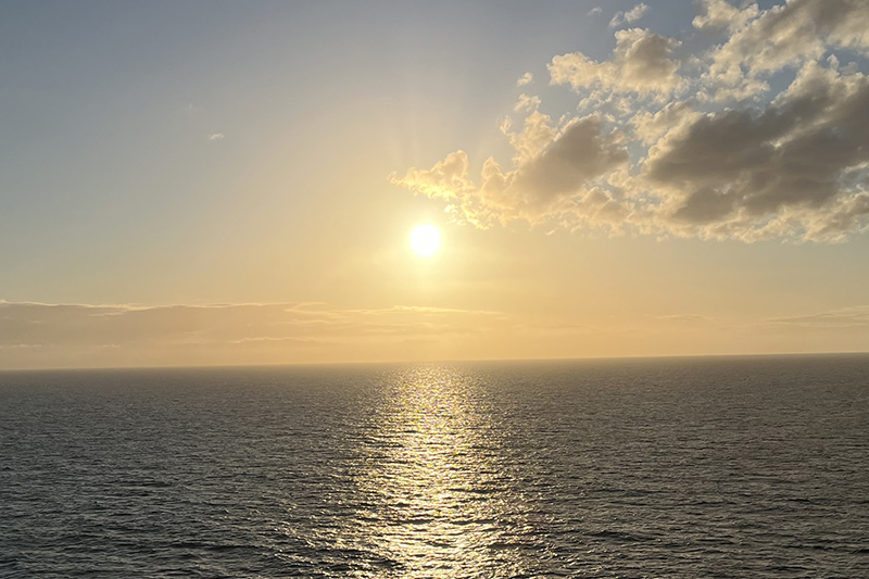 Picture of the Sun coming up over water.